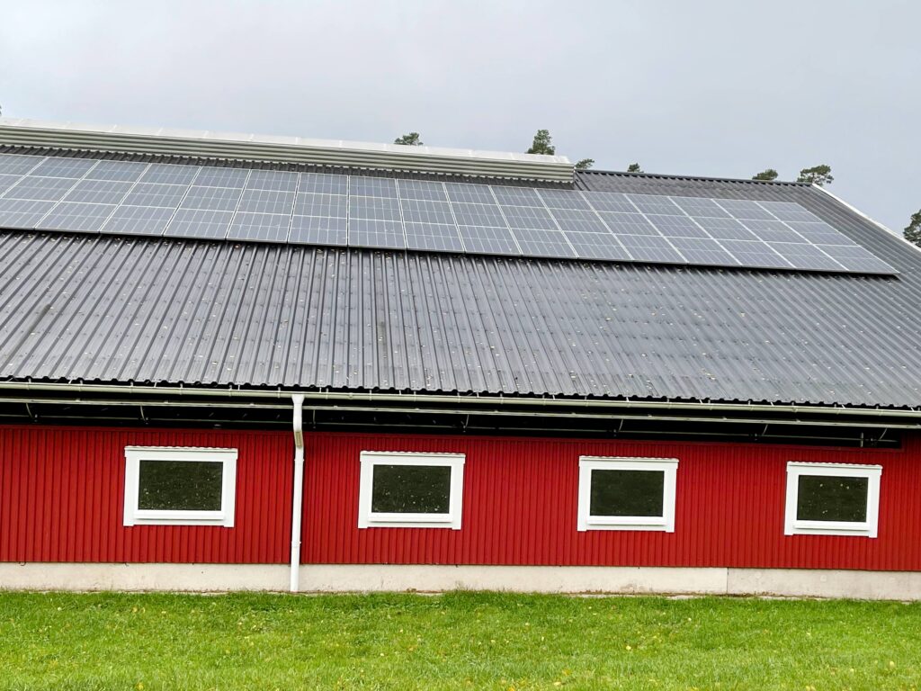 Solceller och paneler för lantbruk satta på en ladugård