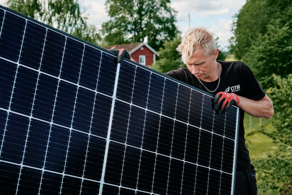 montör som installerar solcellspaneler på tak